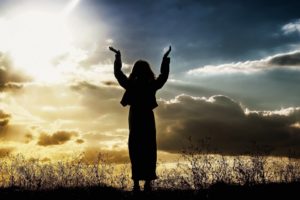 woman holding up arms to sky