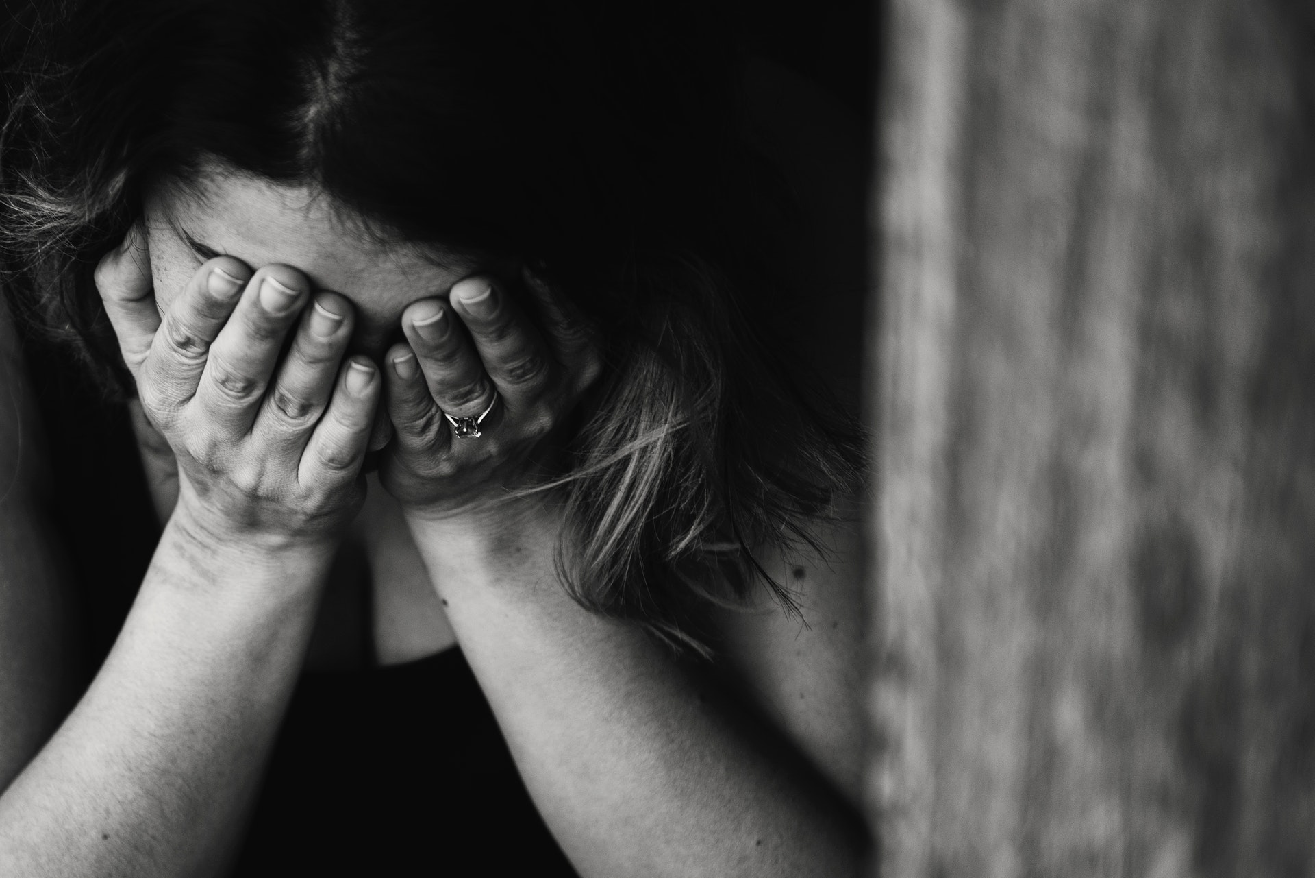 black and white photo of someone with their head in their hands